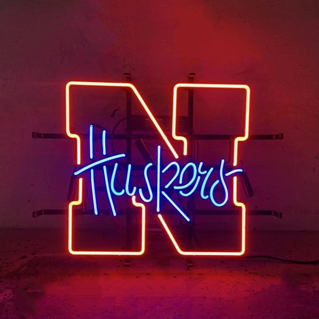 The University of Nebraska Huskers Custom Neon Sign– Handcrafted glass tubing with classic scarlet 'N' logo and team name font in perfect harmony, featuring dynamic two-tone lighting (red/blue)